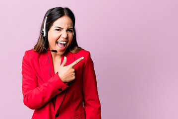 hispanic pretty woman looking excited and surprised pointing to the side. telemarketing concept