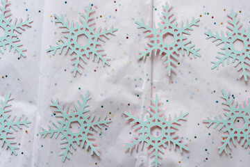 light blue paper snowflakes on tissue paper with glitter spots