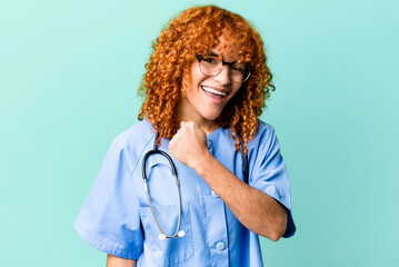 red hair pretty woman feeling happy and facing a challenge or celebrating. nurse concept