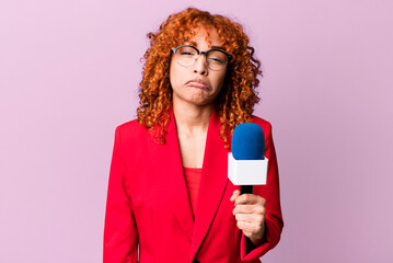red hair pretty woman feeling sad and whiney with an unhappy look and crying. journalist and...