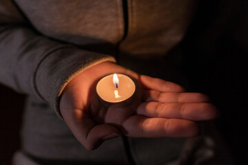Blackout. Power outage concept. Girl holding a burning candle in her hands