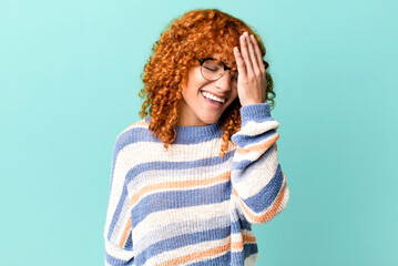 redhair pretty woman laughing and slapping forehead like saying d’oh! I forgot or that was a...