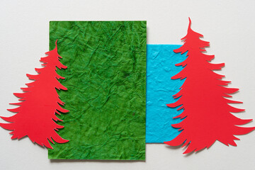 red paper holiday tree shapes on green and blue paper