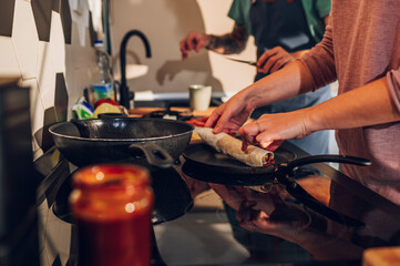 Young couple making breakfast together in the kitchen at home