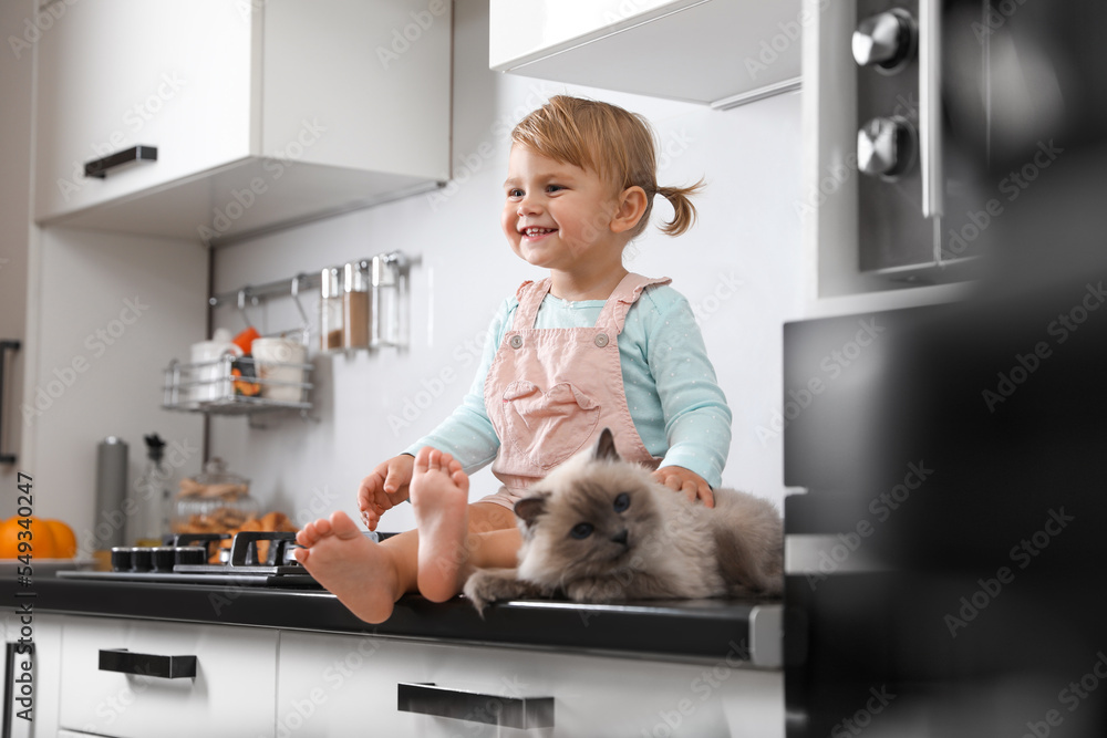 Canvas Prints Cute little child sitting with adorable pet on countertop in kitchen