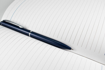 A blue ballpoint pen lying obliquely on a blank-lined page