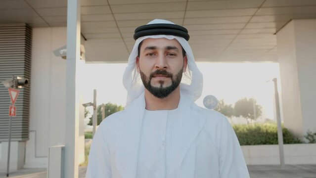 Walking Emirati Arab man on UAE style Kandura. Bearded guy on Ghutra Middle Eastern head wear walks forward