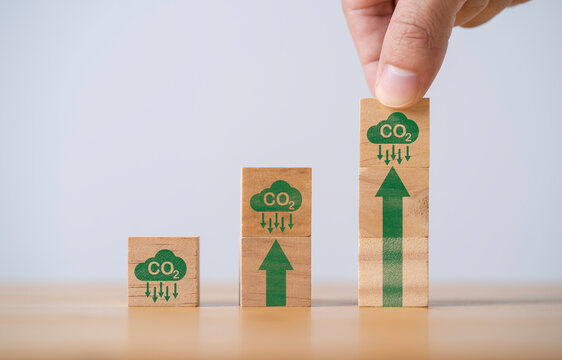 Hand stacking CO2 reducing icon with up arrow for decrease CO2 , carbon footprint and carbon credit to limit global warming from climate change, Bio Circular Green Economy concept.