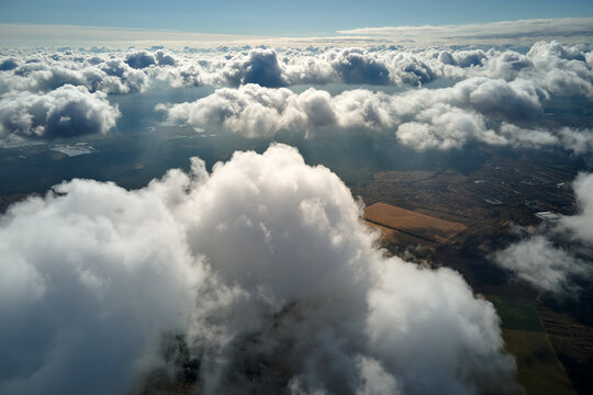 Aerial view at high altitude of earth covered with puffy cumulus clouds forming before rainstorm
