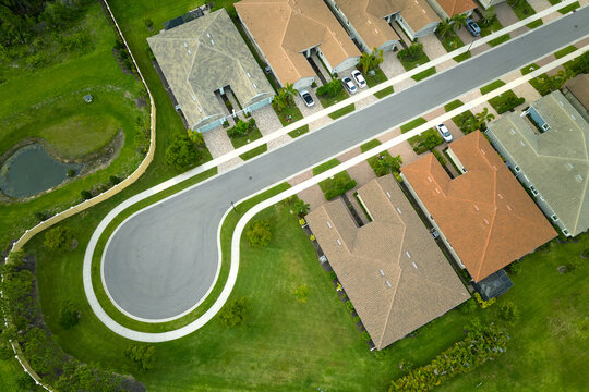 Aerial view of cul de sac at neighbourhood road dead end with densely built homes in Florida closed living area. Real estate development of family houses and infrastructure in american suburbs