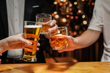 food and drink male friends are happy drinking beer and clinking glasses at a bar or pub.