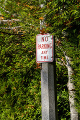 No parking sign against green bushes