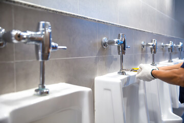 Hand of handyman or plumber is using a wrench to fix or repair leaking water pipes, faucets or...