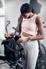 Black woman, water bottle or fitness bag in gym workout break, cardio training or heart health...
