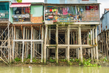 Rustic houses mounted high on tall poles over a river at Chau Doc in Vietnam