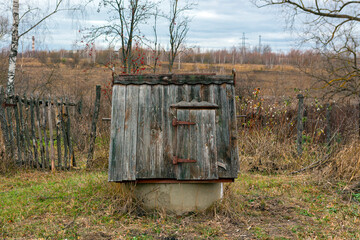 Retro wooden water well in the countryside.