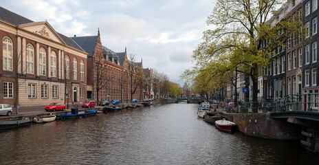 Naklejka premium Amsterdam canals and typical houses with a morning spring sky.