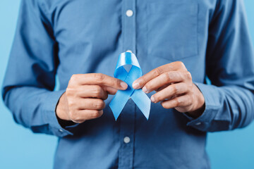 men hands showing Blue ribbon for supporting people living and illness, Colon cancer, Colorectal...