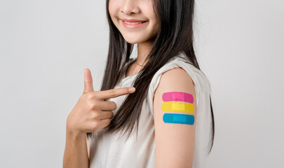 Young woman after getting a vaccine. showing shoulder arm with bandage after receiving vaccination, herd immunity, side effect, booster dose, vaccine passport and Coronavirus pandemic