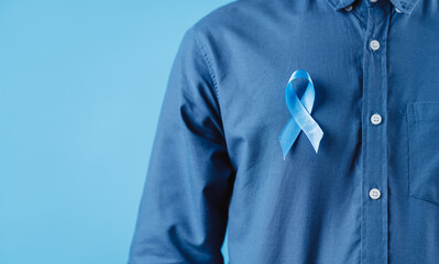 men hands showing Blue ribbon for supporting people living and illness, Colon cancer, Colorectal...