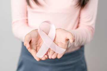 woman hands holding pink ribbon, Breast cancer awareness, world cancer day, national cancer survivor day in february concept...