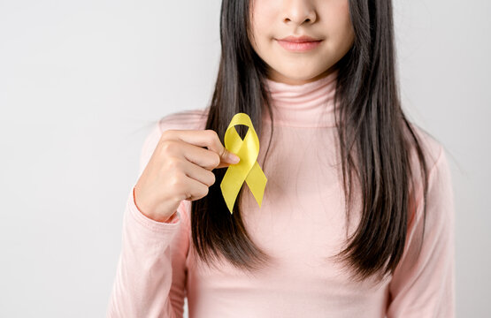 happy woman holding yellow ribbon, september, suicide prevention day, childhood, sarcoma, bone and bladder cancer Awareness month, health care support people and world cancer day concept.