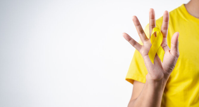 man showing yellow ribbon, september, suicide prevention day, childhood, sarcoma, bone and bladder cancer Awareness month, health care support people and world cancer day concept.