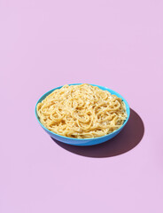 Spaghetti cacio e pepe in a bowl on a purple background