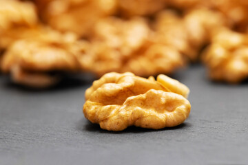 Walnuts. Walnut kernels on dark stone table. Vegetarian or healthy food