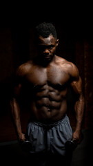 Fototapeta na wymiar Muscular dark-skinned man doing an exercise with dumbbells. 
