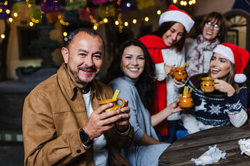 Hispanic senior man portrait holding a cup of fruit punch at traditional posada party for Christmas...