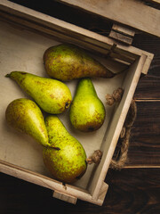 Pears in wooden box on dark wooden table