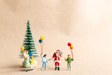 Miniature people, Santa Claus delivering a gift package to children, And the concepts of Christmas and a happy new year.