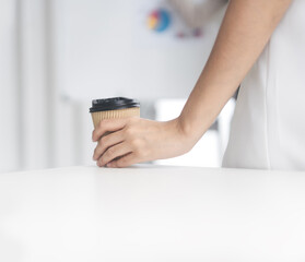 Business woman hand holding cup of coffee drink in office