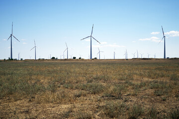 wind power plant in the steppe against the blue sky shooting from a drone