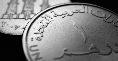 Translation: 1 dirham United Arab Emirates. UAE coins closeup. National currency of  Emirates. Black and white money illustration for stories about economy or finance. Bank and loan. UAE dirham. Macro