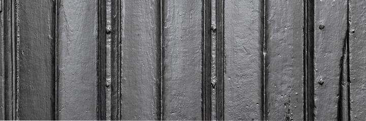 Background texture of old faded wooden panelled door in panorama format