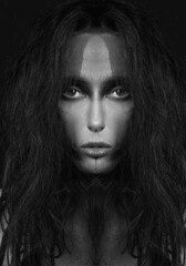 Fine art and sci-fi concept. Abstract and futuristic looking alien or extraterrestrial looking being close-up portrait. Strange looking model with messy hair portrait. Black and white image