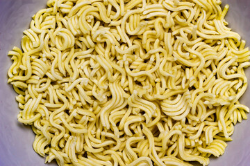 Uncooked instant noodles on white bowl