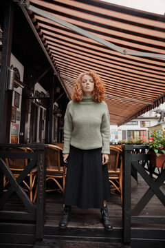 A woman in a beret and a green sweater at cafe