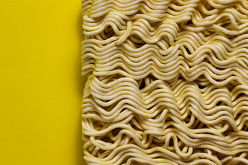 Uncooked instant noodles isolated on yellow background