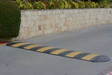 Striped rubber sleeping policeman on asphalt road