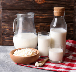 Tasty fresh milk and cottage cheese on grey table. Space for text
