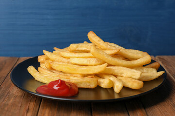 Tasty french fries served with ketchup on wooden table, closeup