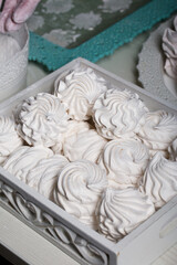 Homemade zephyr. White tray with marshmallows. Stands on black pine boards.