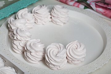Obraz na płótnie Canvas Homemade zephyr. White tray with marshmallows. Stands on black pine boards.