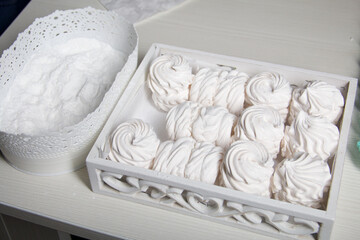 Homemade zephyr. White tray with marshmallows. Nearby is a container of dextrose. For processing...