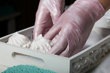 Homemade zephyr. Homemade marshmallows. A woman puts a ready-made zephyr on a tray.