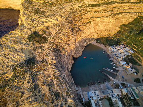 Aerial sunset view of Dwejra, a lagoon of seawater on the island of Gozo. Small fishermen village and Sea Tunnel .Example of Inland sea in Malta.