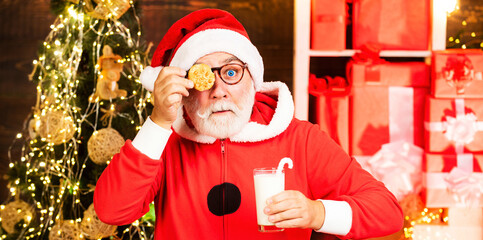 Portrait of funny Santa. Christmas cookies and milk. Santa hold cookie and glass of milk. Merry Christmas and happy new year.